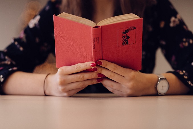 Someone reading a libellus, a small book. From https://www.pexels.com/photo/adult-blur-book-business-287336/